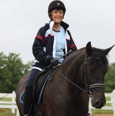 Esther & Briosa Smiling woman riding a black horse outside
