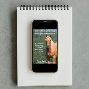 Guide to Buying Your First (or next) Horse displayed on smartphone on top of note pad