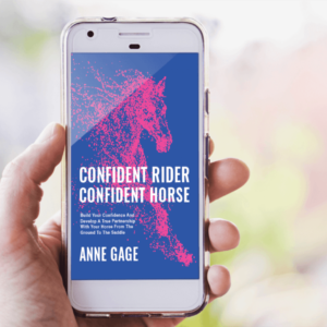 Hand holding a smart phone displaying Confident Rider Confident Horse pdf book